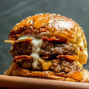 Mouth-watering double beef cheeseburger with bacon and cheese sauce.